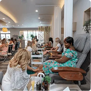 Guests relaxing in pedicure chairs inside the bright, tidy interior of Pamprd Soul nail salon